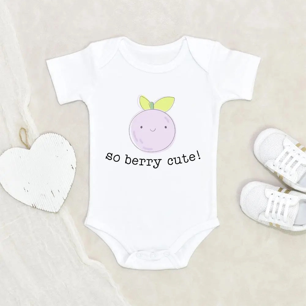 white onesie with a blueberry on it that says so berry cute next to a heart and baby shoes