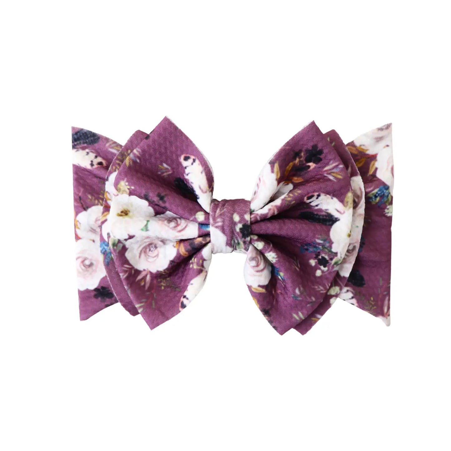 Big bow with a purple background that has white flowers 